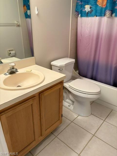 Full bathroom with shower / bath combo with shower curtain, vanity, and light tile patterned floors