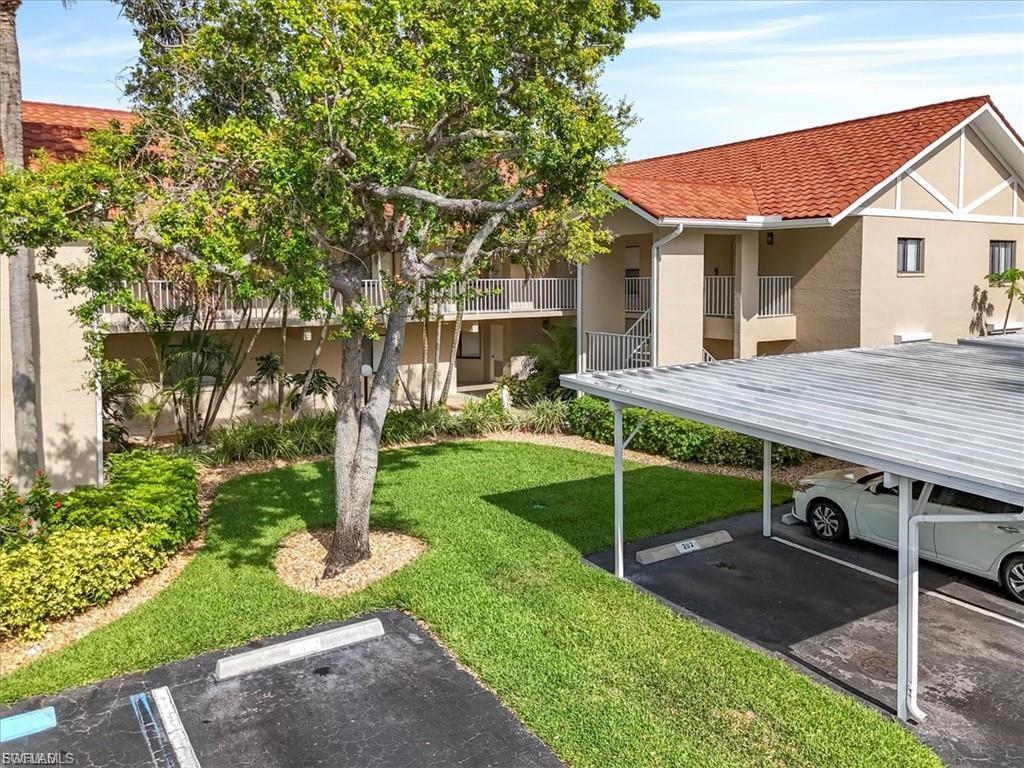 View of home's community with a balcony and uncovered parking