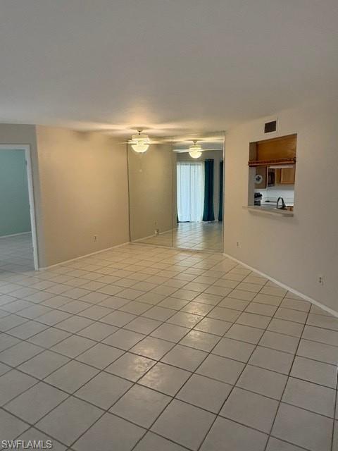 Unfurnished room featuring light tile patterned flooring and a ceiling fan