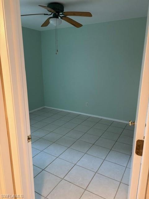 Unfurnished room featuring light tile patterned floors and a ceiling fan