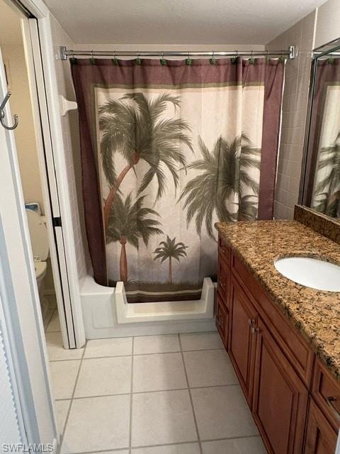 Bathroom with vanity, shower / bathtub combination with curtain, and light tile patterned floors