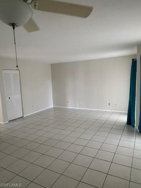 Unfurnished room with light tile patterned flooring and baseboards