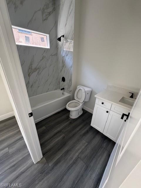 Full bath featuring vanity, dark wood finished floors, and tub / shower combination