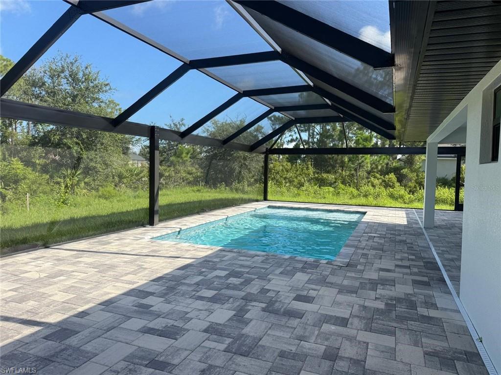 Swimming pool featuring a lanai, a patio, and a sunroom