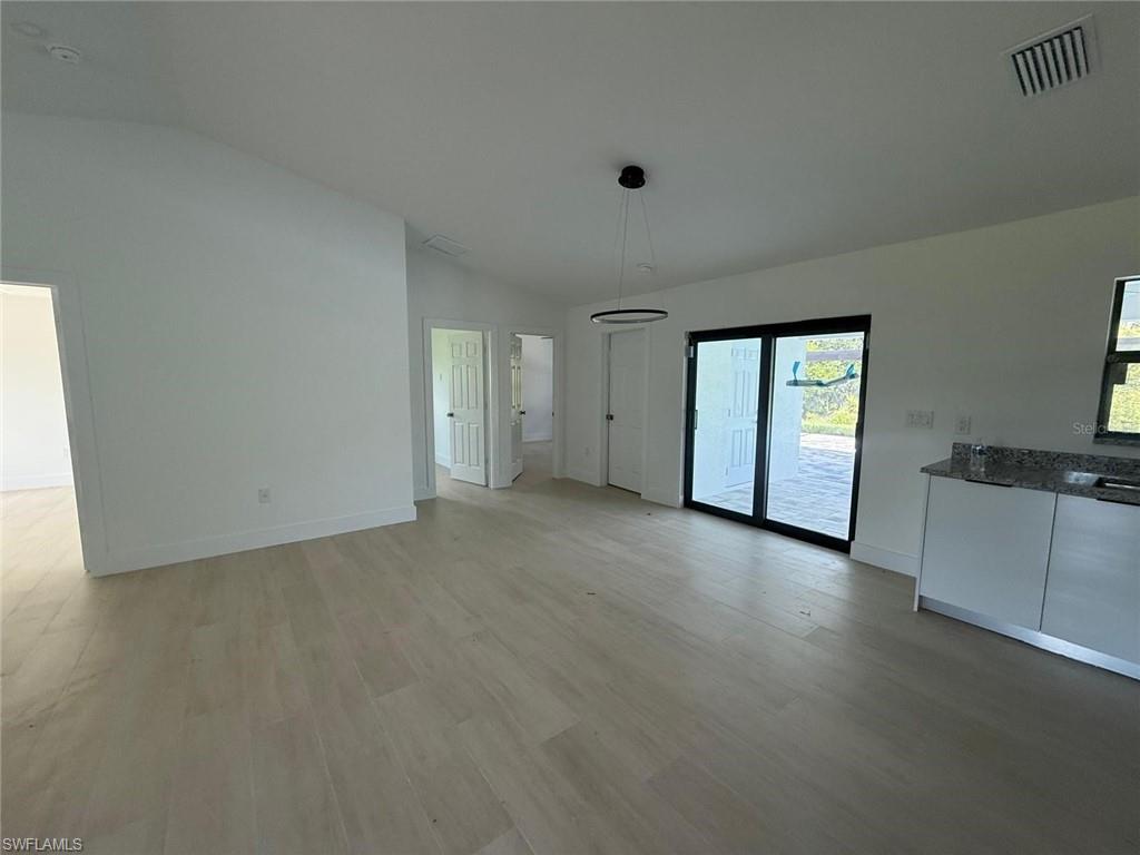 Unfurnished dining area with vaulted ceiling and light wood finished floors
