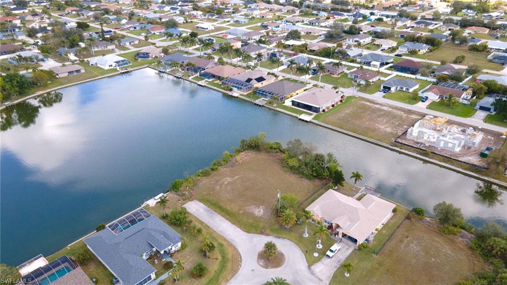 Aerial view of property and surrounding area featuring a large body of water and nearby suburban area