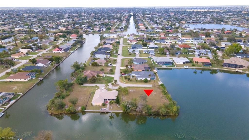 Aerial view of property and surrounding area with a nearby body of water and nearby suburban area