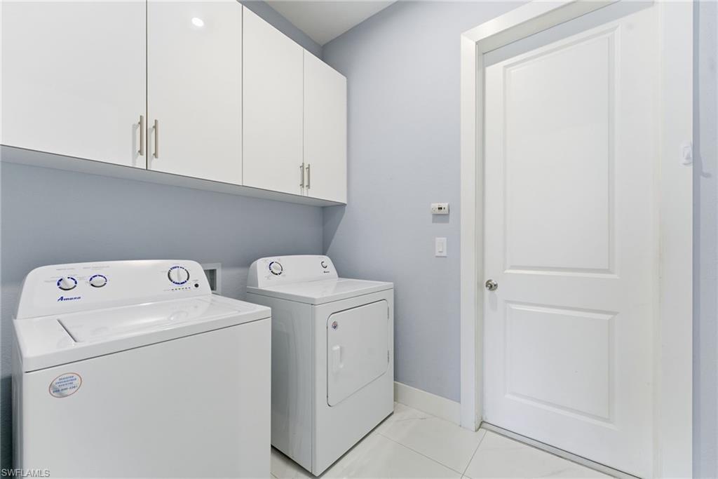 Laundry area featuring cabinet space and washer and clothes dryer