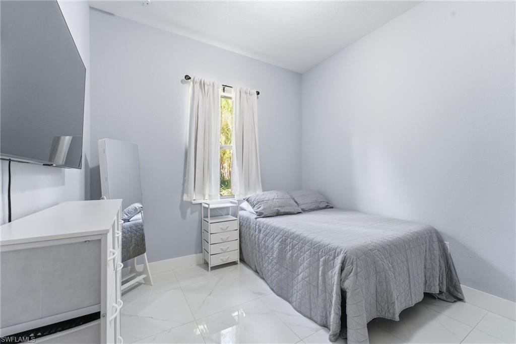 Bedroom with baseboards and lofted ceiling