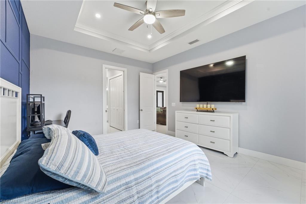 Bedroom featuring ceiling fan and a tray ceiling