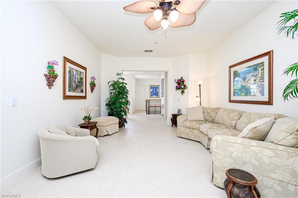 Tiled living room with architectual baseboards & ceiling fan