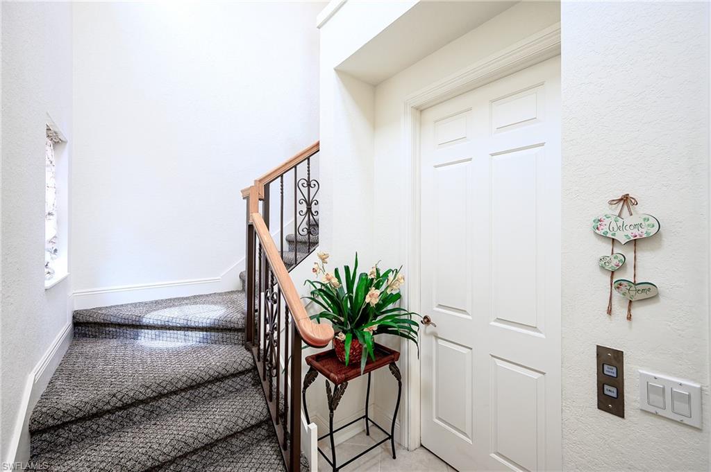 Staircase with a textured wall and carpet flooring