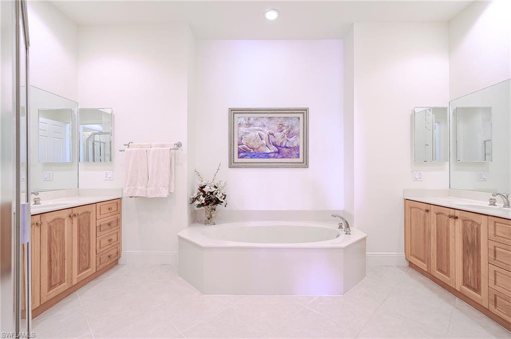 Master bath with dual vanities, soaking tub, shower and private toilet