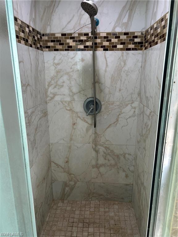 Full bath with a marble finish shower