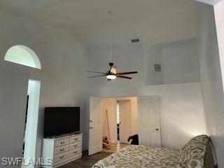 Bedroom with lofted ceiling, dark wood-style flooring, and a ceiling fan
