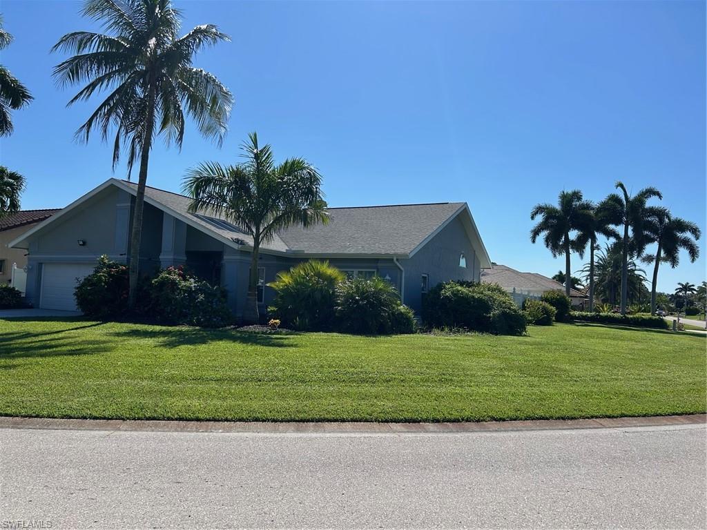 View of front of property featuring a front lawn and a garage