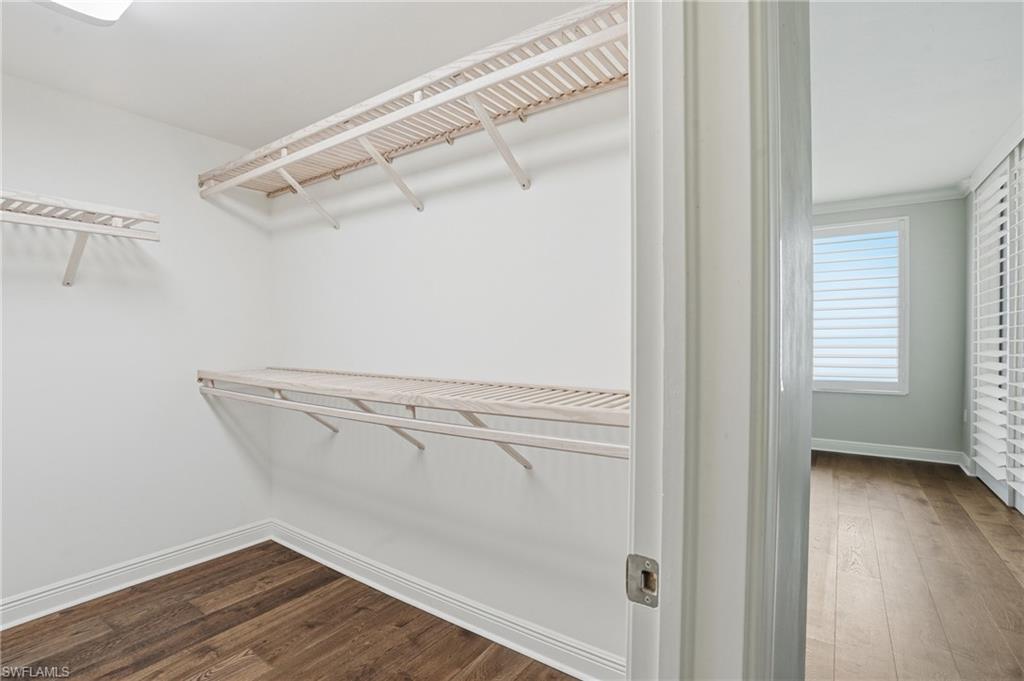 Walk in closet featuring hard wood flooring