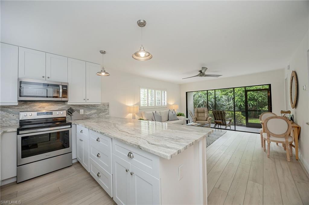 Contemporary kitchen featuring white cabinetry, stainless steel appliances, and a light-toned countertop