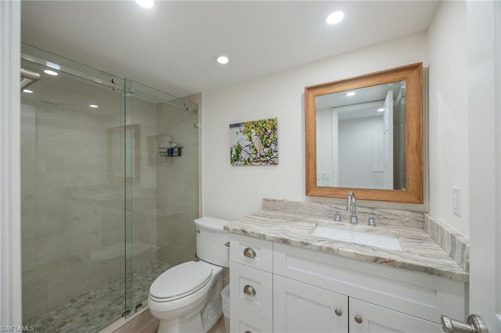 Glass-enclosed shower with a pebble floor and tiled walls