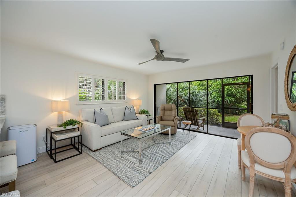Light wood-finish flooring, white walls, and a ceiling fan
