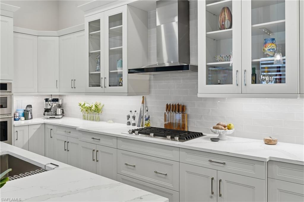 Bright white cabinetry paired with sleek quartz surfaces and stainless appliances create a timeless, modern feel.