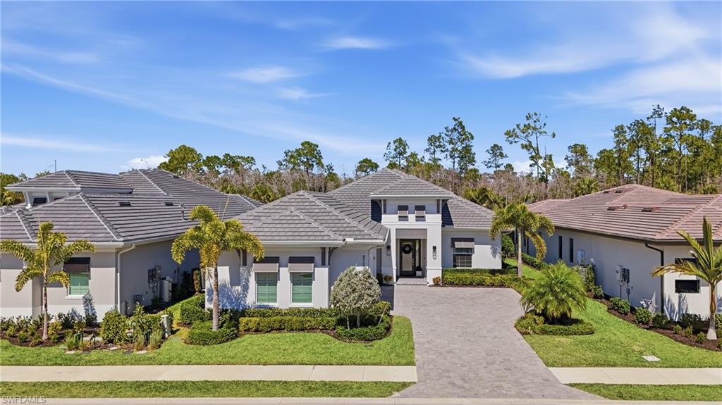 Refined coastal elevation with manicured landscaping and oversized three car garage.