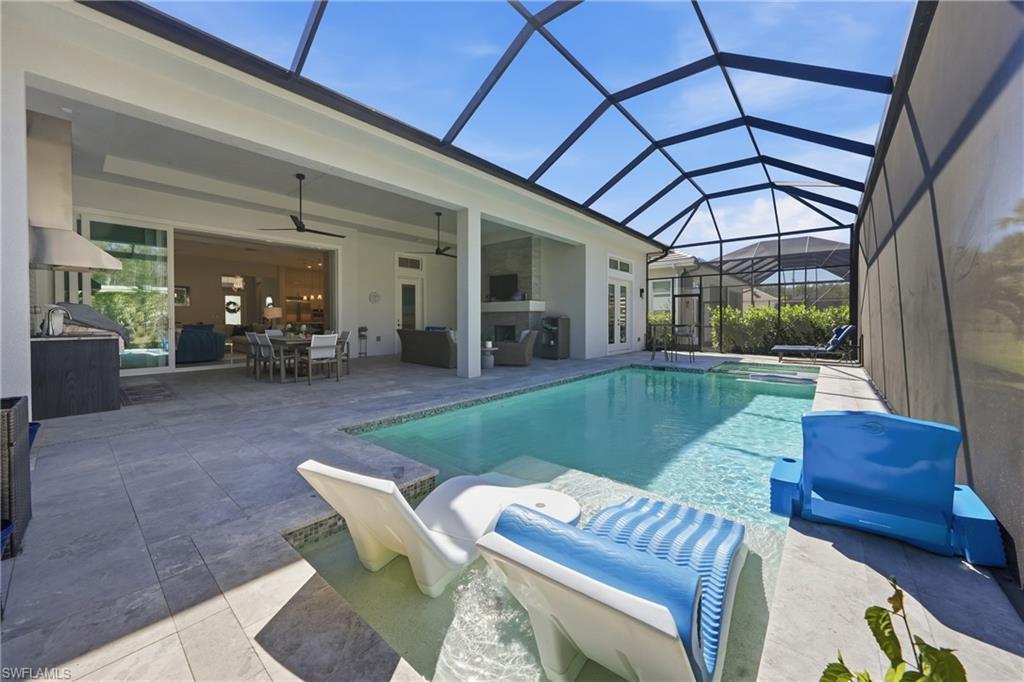 Custom heated pool and spa framed by an expansive screened enclosure and preserve views.