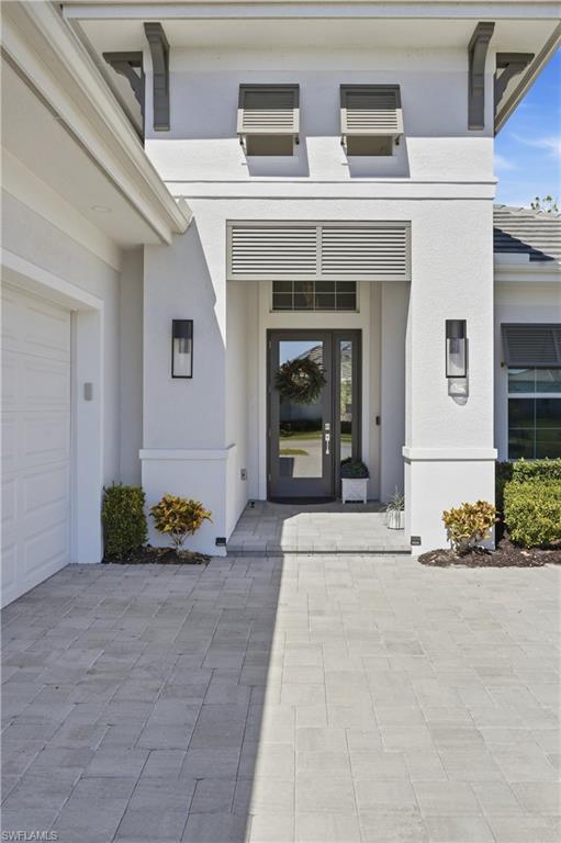 Grand entry framed by impact glass and natural light, setting the tone for the open concept design.