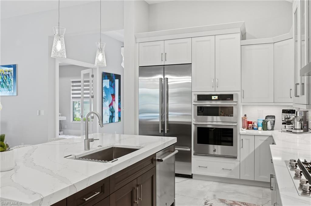 Chef inspired kitchen featuring quartz countertops, gas cooktop, wall oven and oversized island with seating.