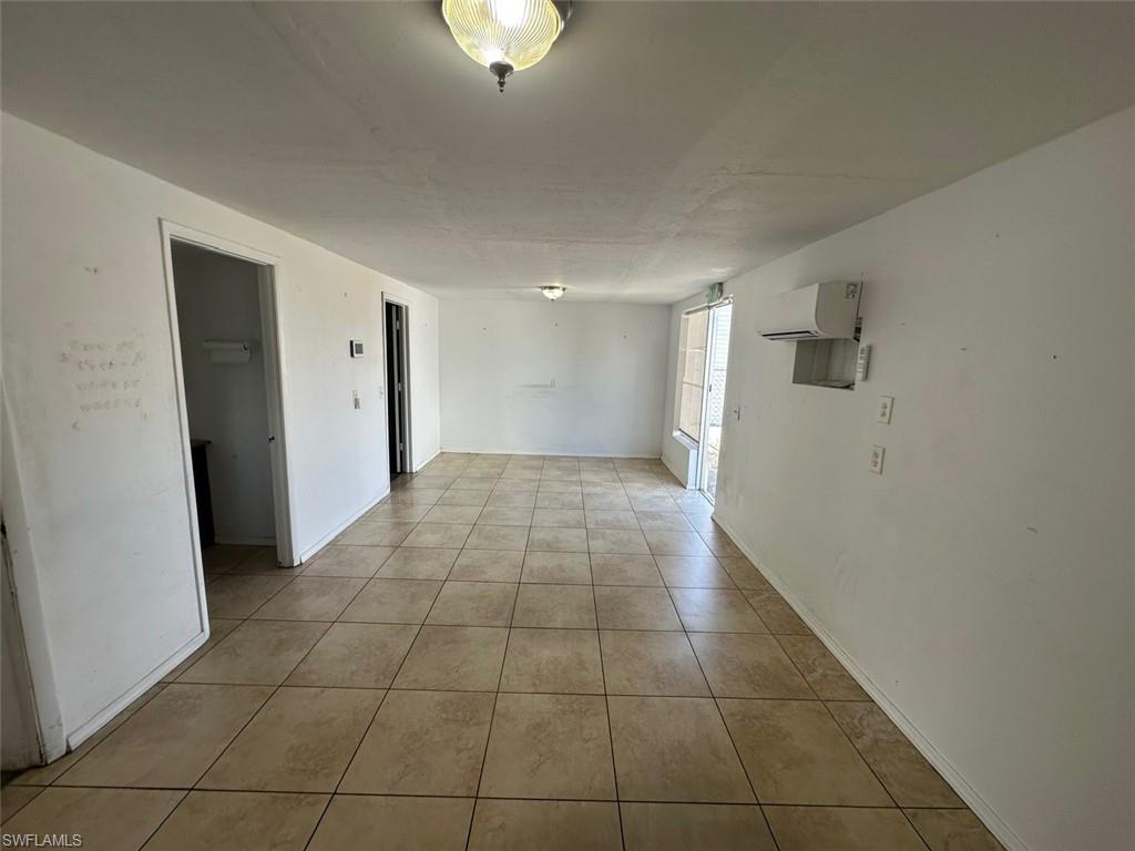Unfurnished room featuring light tile patterned floors and a wall mounted mini split