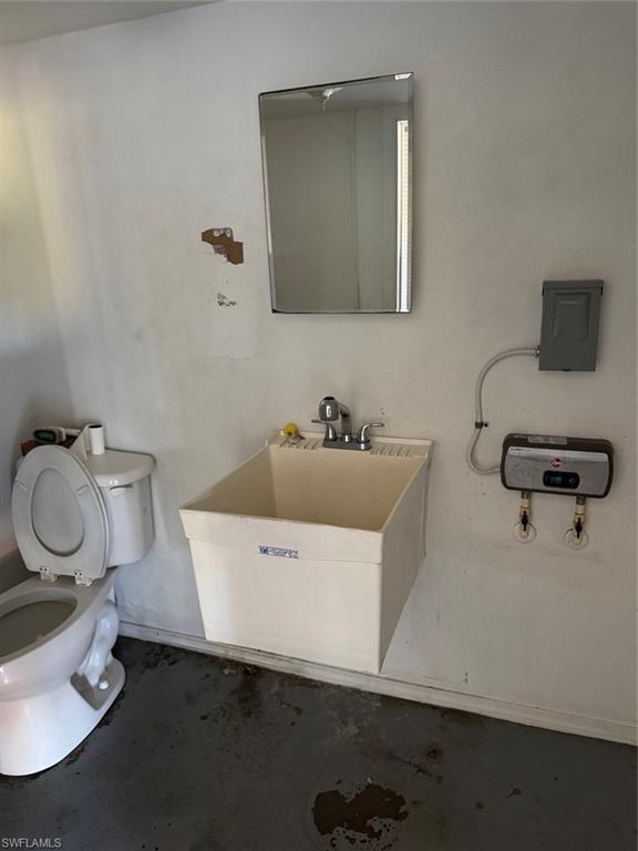 Bathroom with toilet and concrete floors