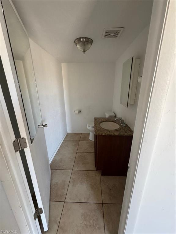 Half bath with vanity and light tile patterned floors