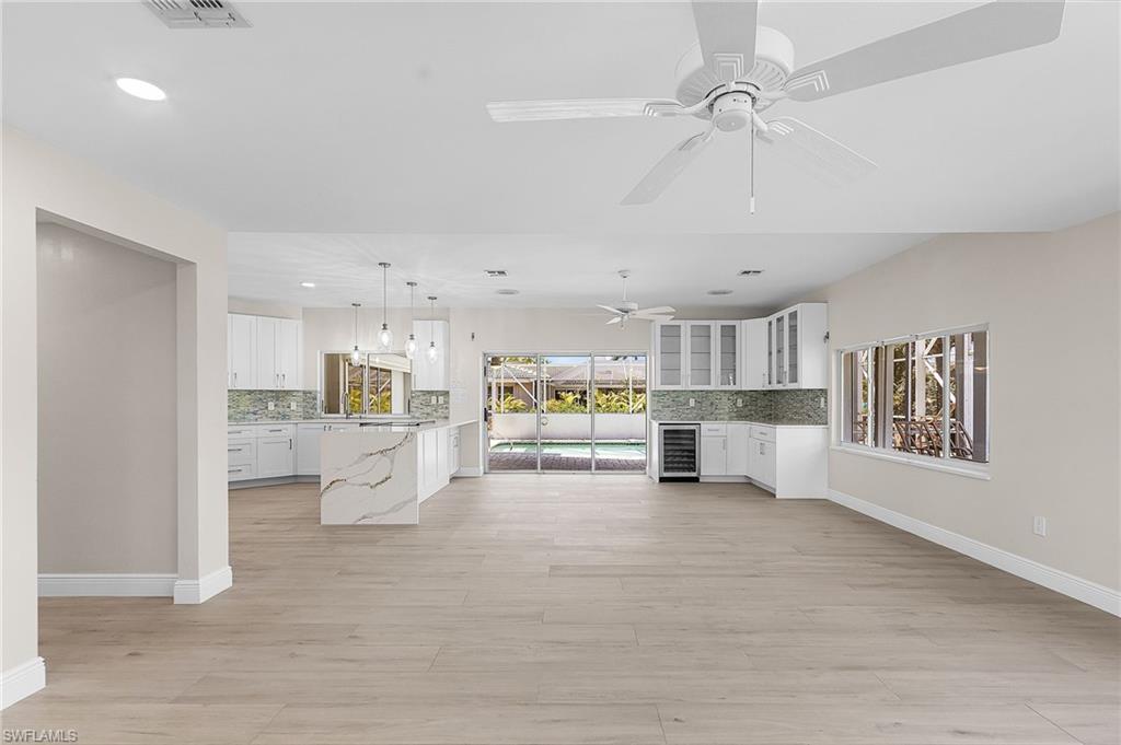 Family room with beverage cooler, light wood-style flooring, recessed lighting, and a ceiling fan