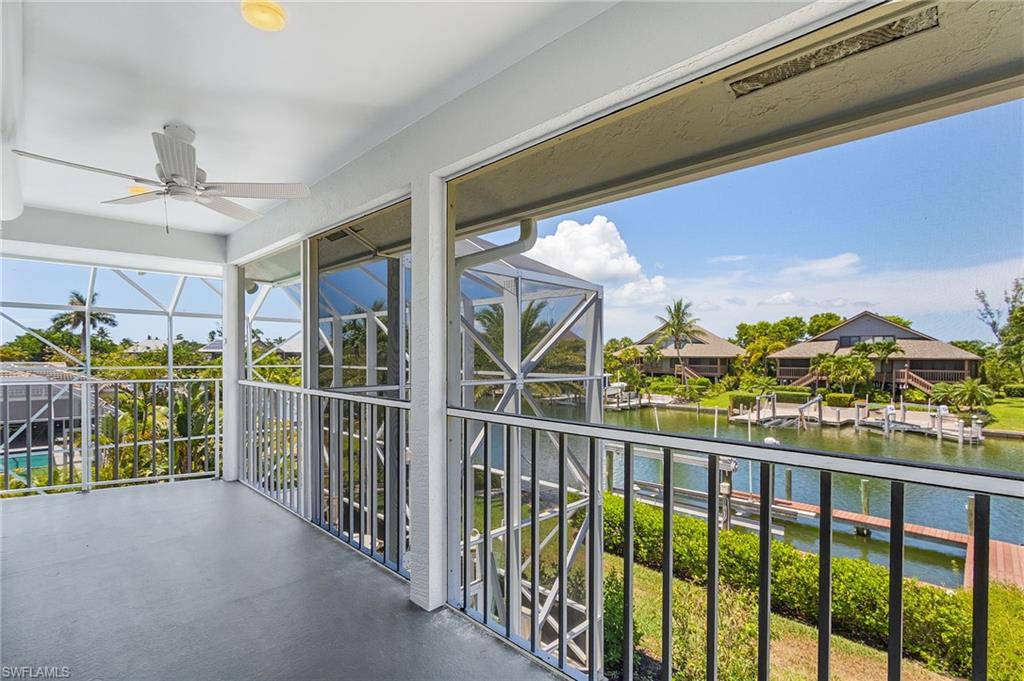 Balcony featuring a ceiling fan, a water view, and a sunroom
