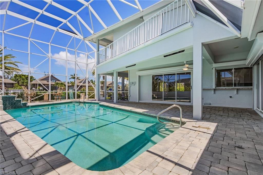 Swimming pool with a patio, a sunroom, a lanai, and a balcony