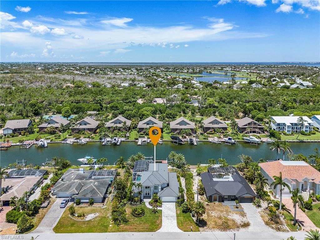 Aerial view of residential area featuring a tree filled landscape and a large body of water