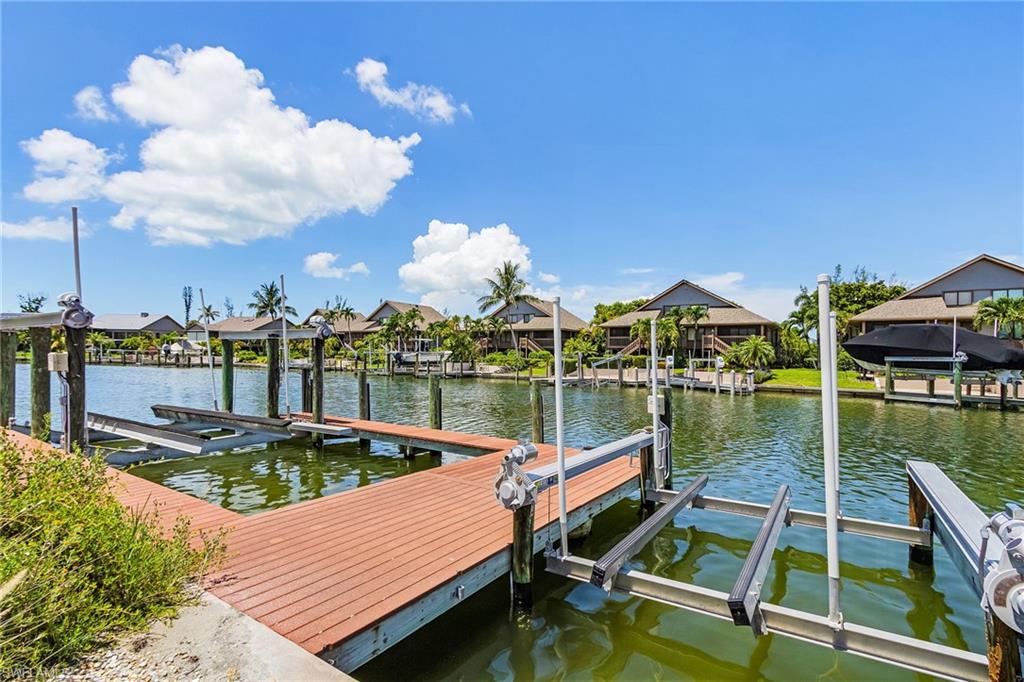Dock featuring boat lift, a residential view, and a water view