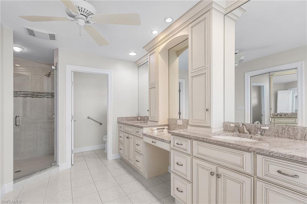 Primary Bathroom with a ceiling fan, double vanity, a shower stall, recessed lighting, and light tile patterned floors