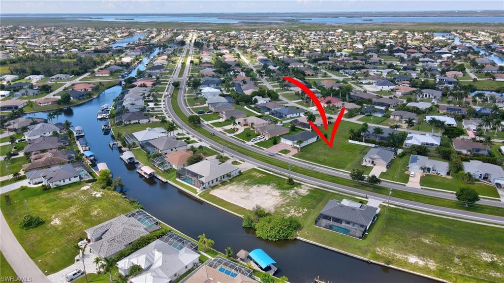 Aerial view of property's location featuring a large body of water and nearby suburban area