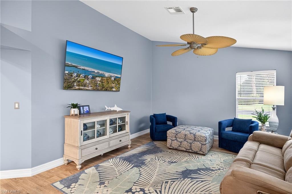 Living area with wood finished floors, ceiling fan, and lofted ceiling