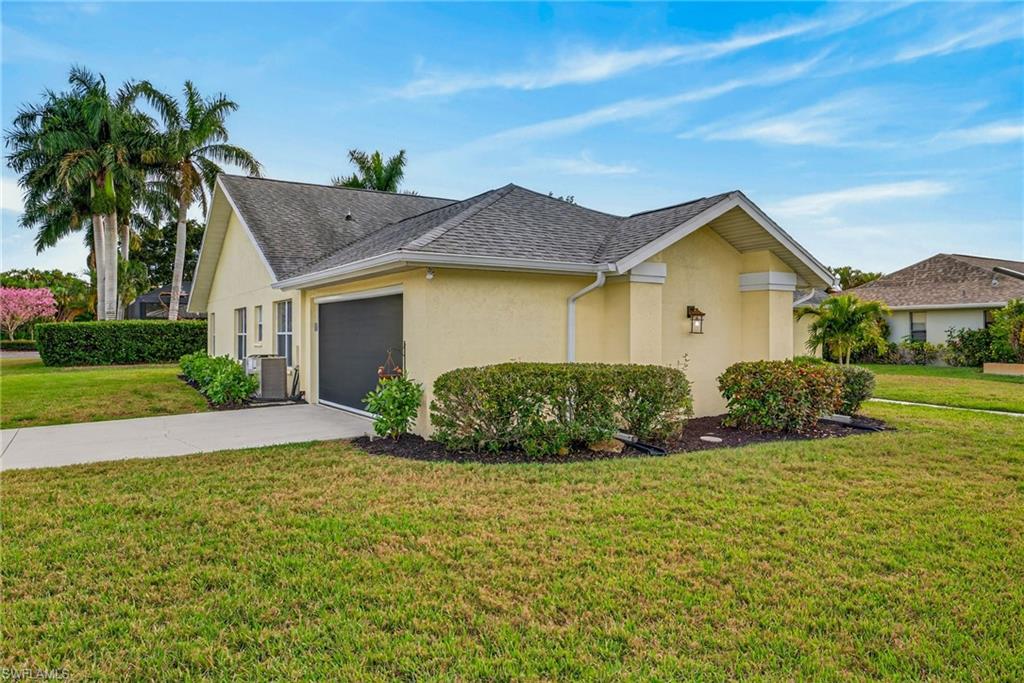 View of front of home featuring a front lawn, stucco siding, driveway, a garage, and a shingled roof