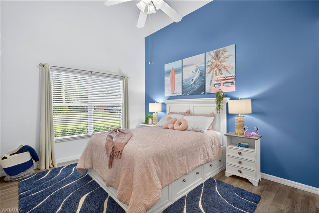 Bedroom featuring dark wood-style floors, ceiling fan, and a high ceiling