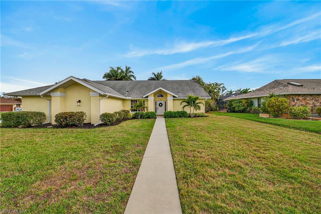 Single story home with a front lawn and stucco siding