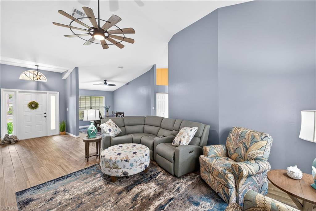 Living area featuring wood finished floors, ceiling fan, and lofted ceiling