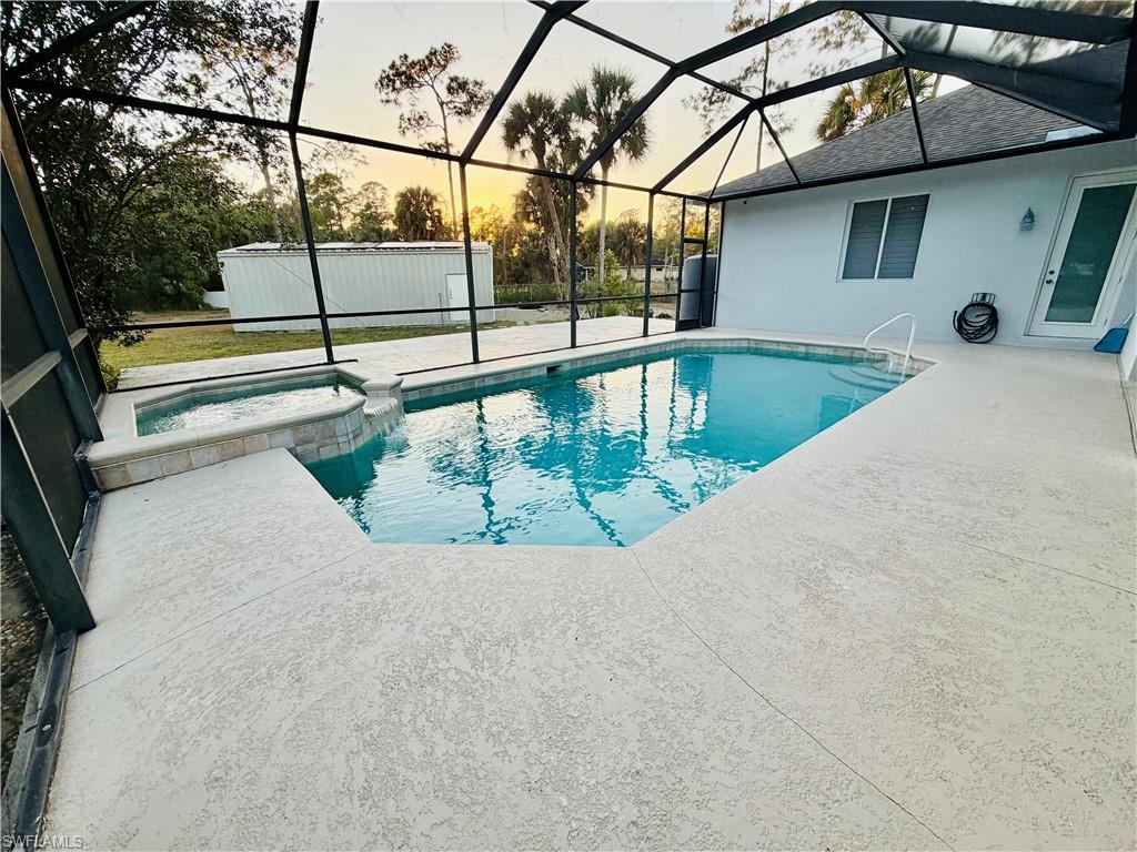 Integrated pool / spa featuring a sunroom, a patio area, and glass enclosure