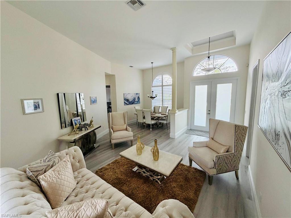 Living room featuring wood finished floors, french doors, and a chandelier