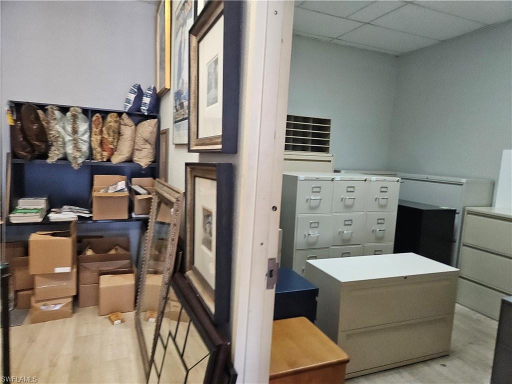 Bedroom featuring light wood-style floors and a drop ceiling