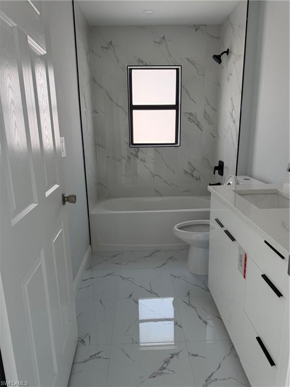 Full bath featuring vanity, shower / bath combination, and light marble finish flooring
