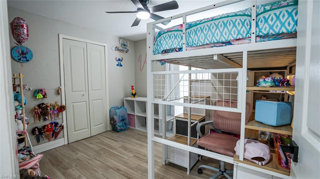 Bedroom with light wood-style floors, a ceiling fan, and a closet