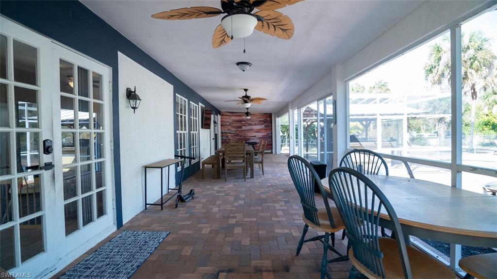 Sunroom with outdoor dining space, french doors, and ceiling fan